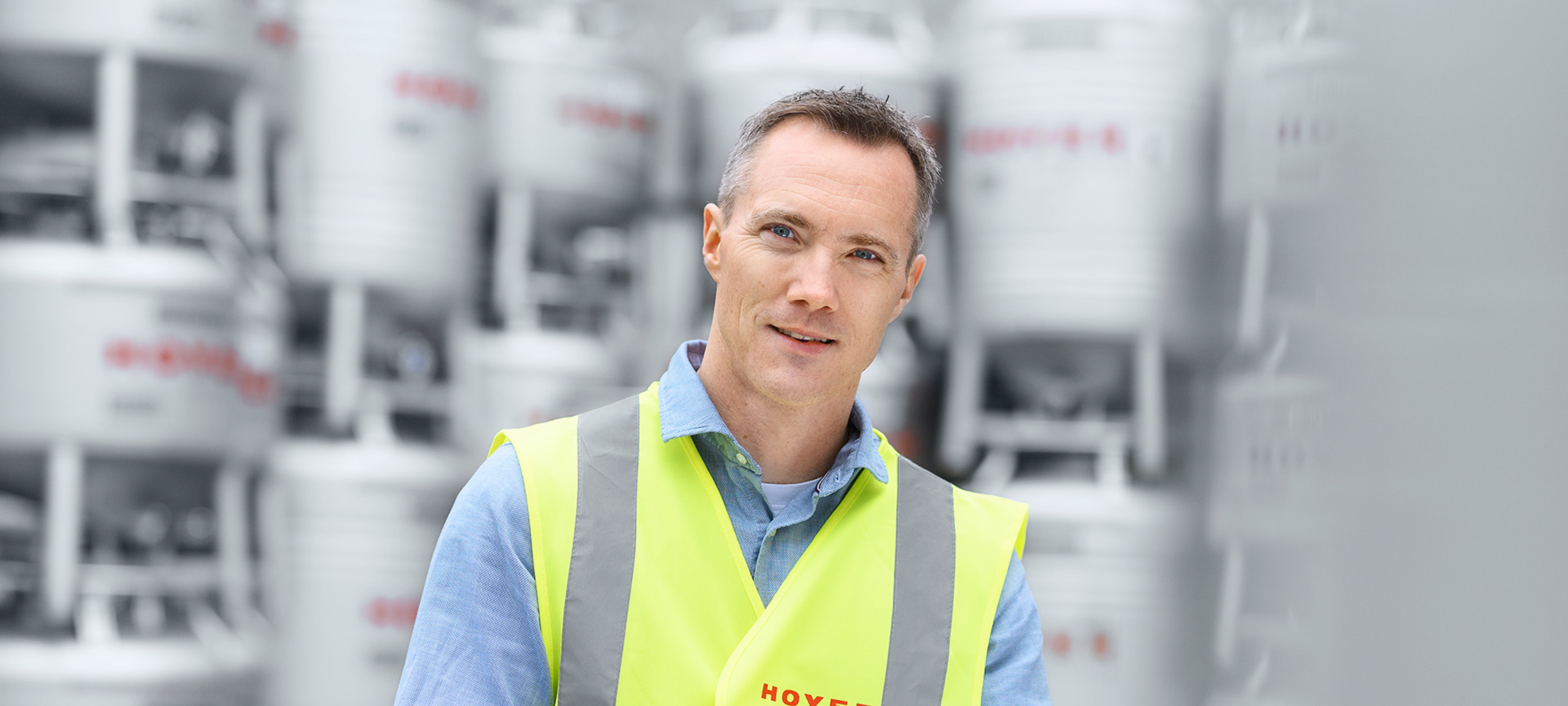 Mitarbeiter mit tablet steht vor dem IBC Depot.